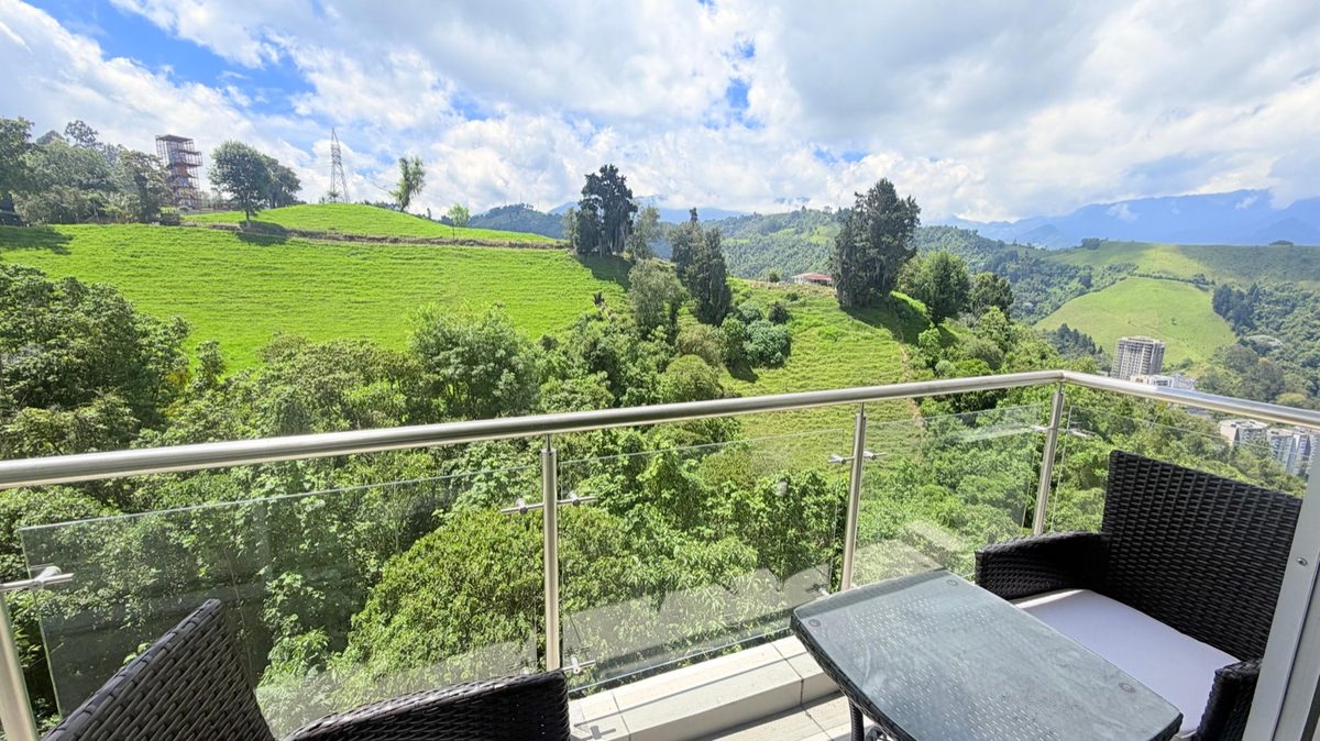 Balcón con terraza y vista verde a las montañas